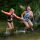2 girls jumping into the river