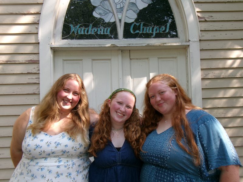 The 3 Meehan sisters - Rachel, Clara and Ruth - stand together outside Wadena Chapel.