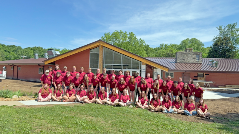 2026 summer staff and year-round staff in front of the newly renovated Cedar Lodge.